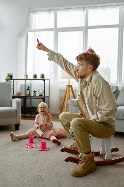 Pai muito feliz com aparência engraçada e filha fofa passando tempo juntos em casa