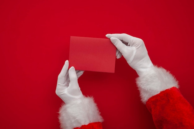 Pai natal segurando uma visão aérea de cartão em branco vermelho