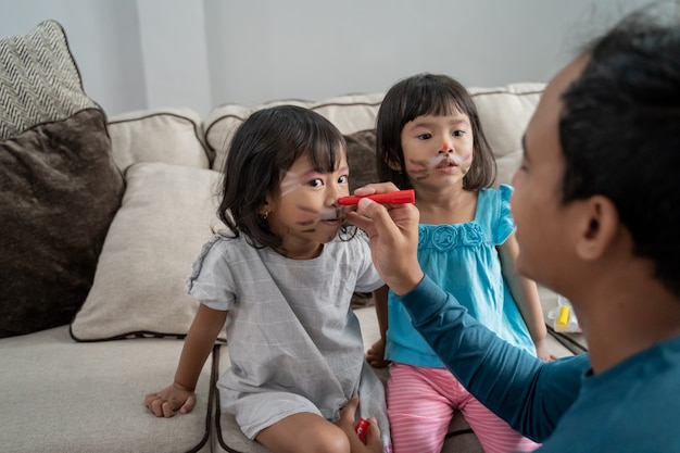 Pai pintar sua filha dois no rosto