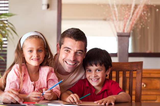 Pai radiante ajudando os filhos para a lição de casa