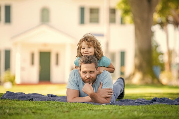 Pai relaxa com garotinho na grama pai com criança no dia de verão parentalidade