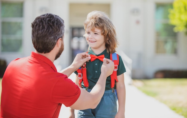 Pai se despedindo de seu filho pequeno perto da escola Educação infantil Primeiro dia na escola