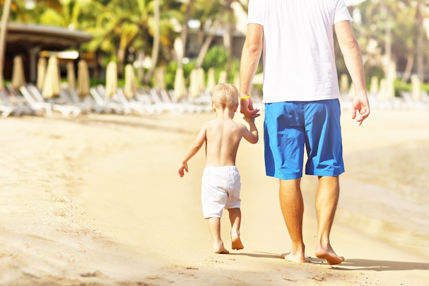 Pai se divertindo na praia com seu filho pequeno