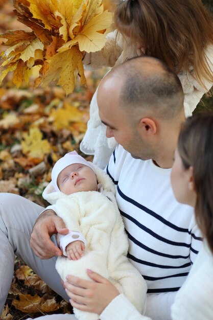 Pai segurando a filha na floresta de outono