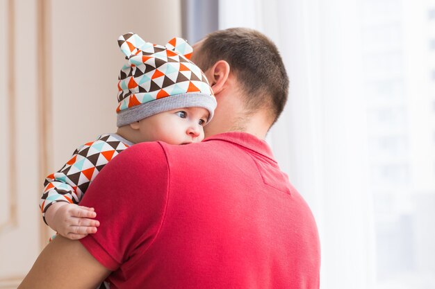 Pai segurando e jogando seu filho bebê.