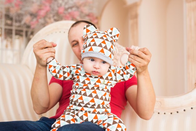 Foto pai segurando filho em casa