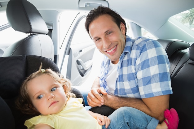 Pai segurando seu bebê no assento do carro
