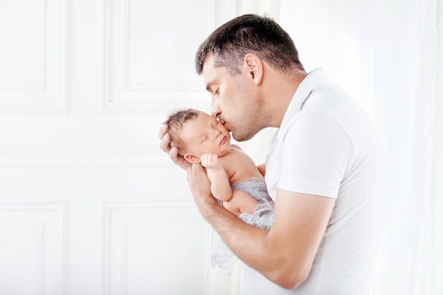 Pai segurando seu bebê recém-nascido nas mãos