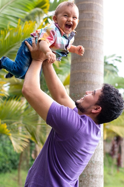 Pai segurando seu filho highbaby sorrindo com seu pai