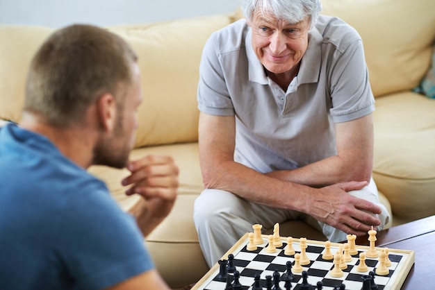 pai sênior homem ou xadrez mate em casa para jogos ou desafio com estratégia ou resolução de problemas sorriso feliz pai maduro ou tabuleiro para jogar ou aprender habilidades de pensamento para a função cognitiva