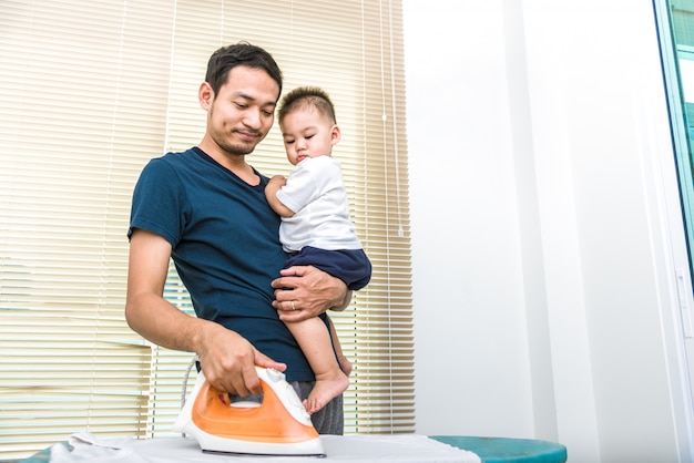 Pai solteiro está passando enquanto carrega seu filho. conceito de pessoas e estilos de vida.