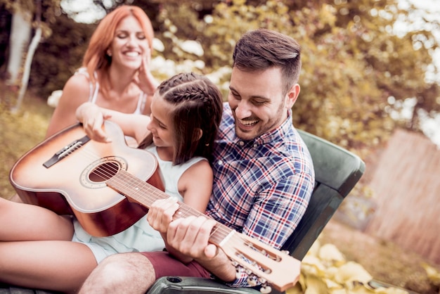 Pai tocando violão para a família