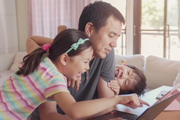 Pai trabalhando em casa com os filhos. ensino em casa, ficar em casa, distanciamento social durante o isolamento de quarentena de coronavírus, conceito de trabalho freelance