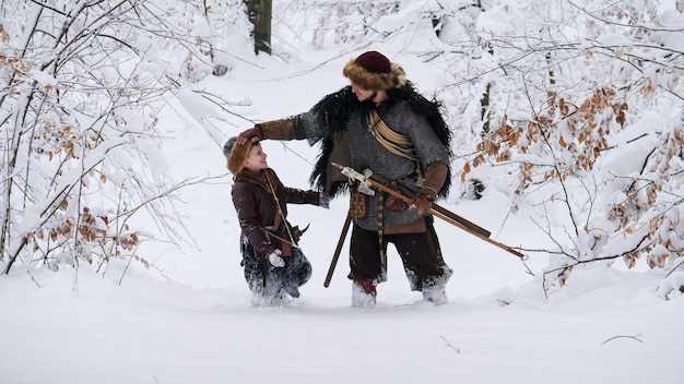Pai viking com seu filho indo para a floresta de inverno