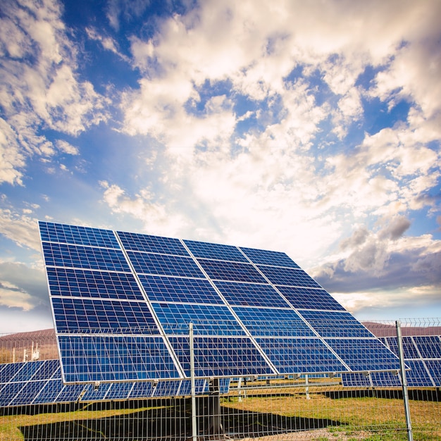 Painéis solares contra paisagem de montanhas e céu azul