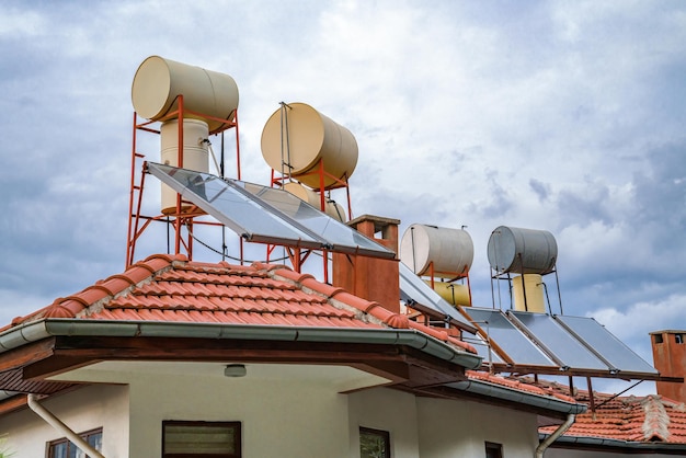 Painéis solares e barris ficam no telhado da casa para aquecer água usando energia solar