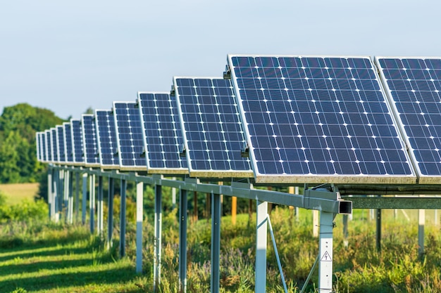 Painéis solares em um campo verde agrícola no campo planta de energia solar painéis solares azuis