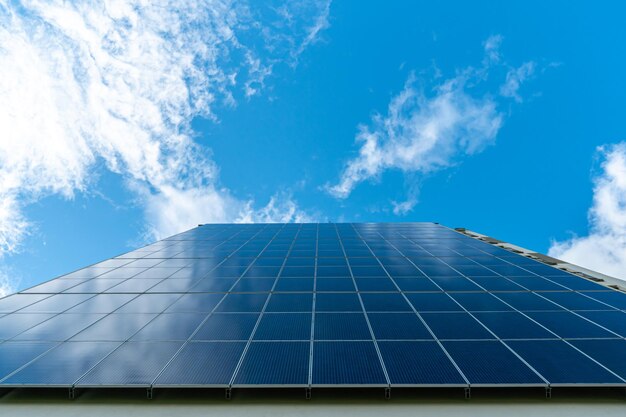 Painéis solares em um fundo de céu azul e nuvens O conceito de energia alternativa Tecnologias avançadas para a produção de energia limpa Espaço vazio para cópia