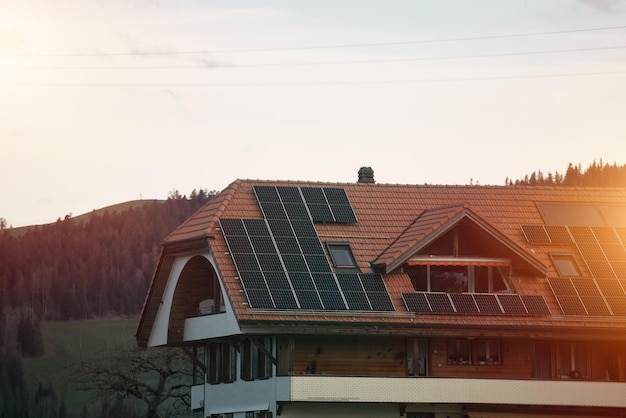 Painéis solares no telhado da casa moderna Casa de campo residencial com sistema de painéis fotovoltaicos solares azuis brilhantes no telhado Conceito de produção de energia verde ecológica renovável Sustentável