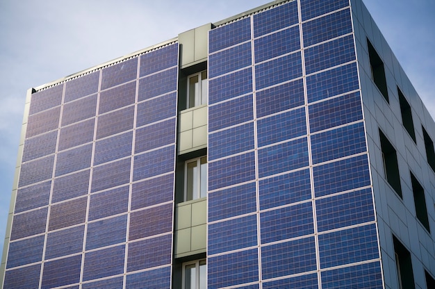 Painéis solares para geração de energia elétrica na parede de um prédio industrial da cidade durante o dia