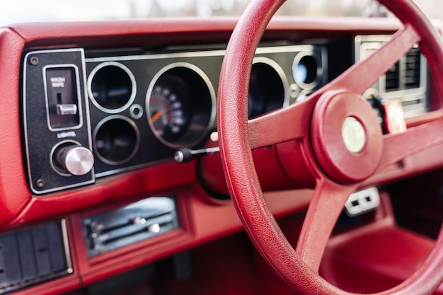 Painel vermelho do volante de um carro americano clássico poderoso velho