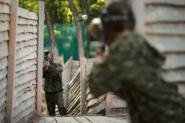 Paintball guerrero dispara con pistola desde el refugio