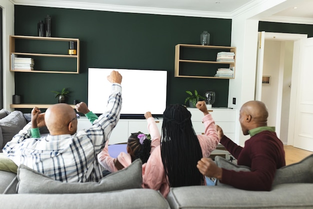 pais afro-americanos filho filha e avô vendo TV com espaço de cópia em câmera lenta