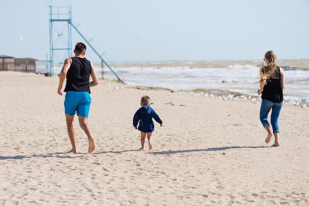 pais caminhando na praia com o filho