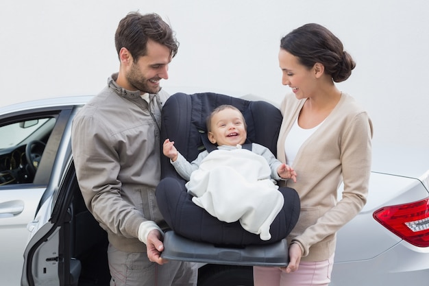 Pais carregando bebê no banco do carro