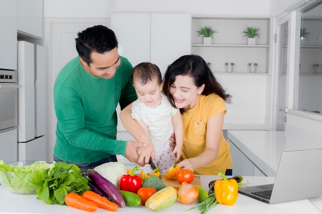 Pais com filha cozinhando em casa