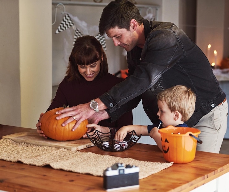 Foto pais criativos ou criança com abóbora para o halloween para comemorar com o jogo filho ou menino para se divertir mãe ou pai em casa com a criança esculpindo rosto em vegetais para decoração de lanterna de férias ou memória familiar