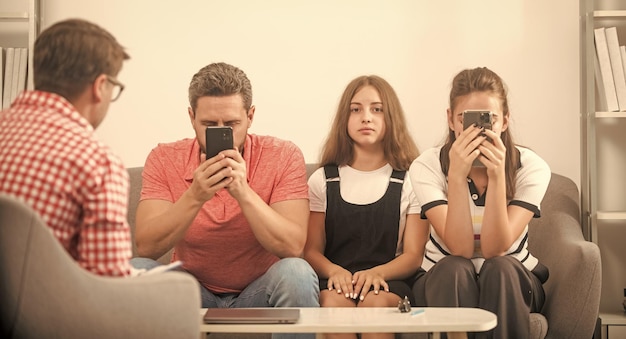 Foto pais de terapia familiar com garota conversam com assistente social, mãe e filha viciadas em telefone