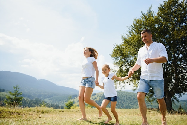 Pais e filha caminhando na natureza