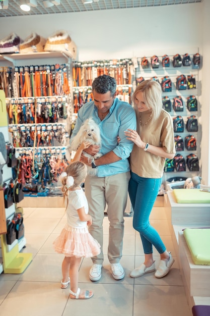 Pais e filha vindo ao pet shop no fim de semana