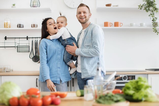 Foto pais e filhos posando na cozinha antes de preparar a salada