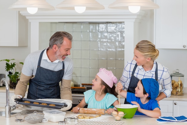 Pais e filhos preparando comida na cozinha