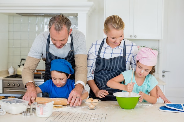 Pais e filhos preparando comida na cozinha