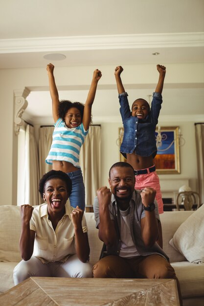 Pais e filhos se divertindo enquanto assistia televisão na sala de estar