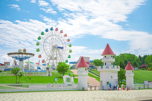 Pais e filhos sorridentes e a aparência do parque de diversões