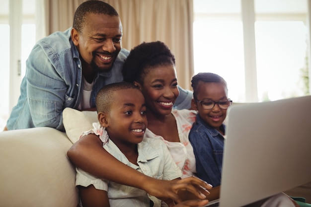 Pais e filhos usando laptop na sala de estar