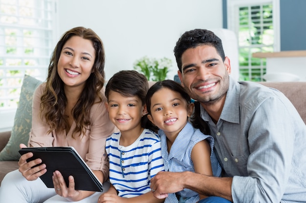 Pais e filhos usando tablet digital na sala de estar em casa