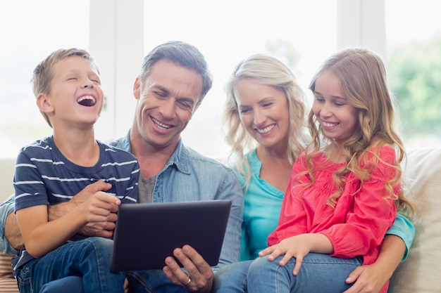 Pais e filhos usando tablet digital na sala de estar