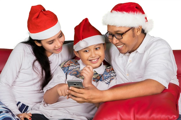 Pais e filhos usando telefone na época do Natal