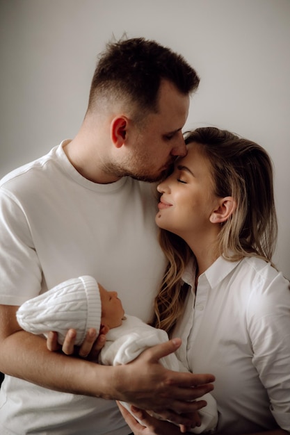 Pais e pais do bebê e bebê recém-nascido na cama