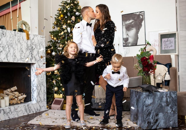 Pais e seus filhos felizes, filha e filho, esperando o Natal em casa Natal em família em casa