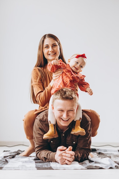 Pais elegantes e bebê posando para uma foto com lindos sorrisos felizes