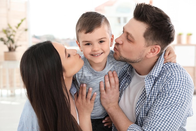 Pais felizes beijando seu filho em casa Hora da família