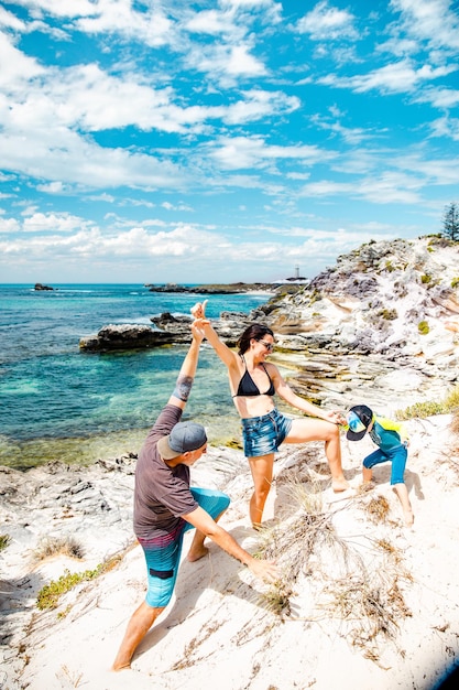 Pais felizes brincando com seu filho em uma bela praia na Austrália.