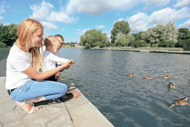 Pais felizes com seu filho sentado no cais do lago. foto com espaço de cópia