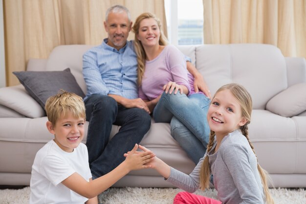 Pais felizes com seus filhos no chão